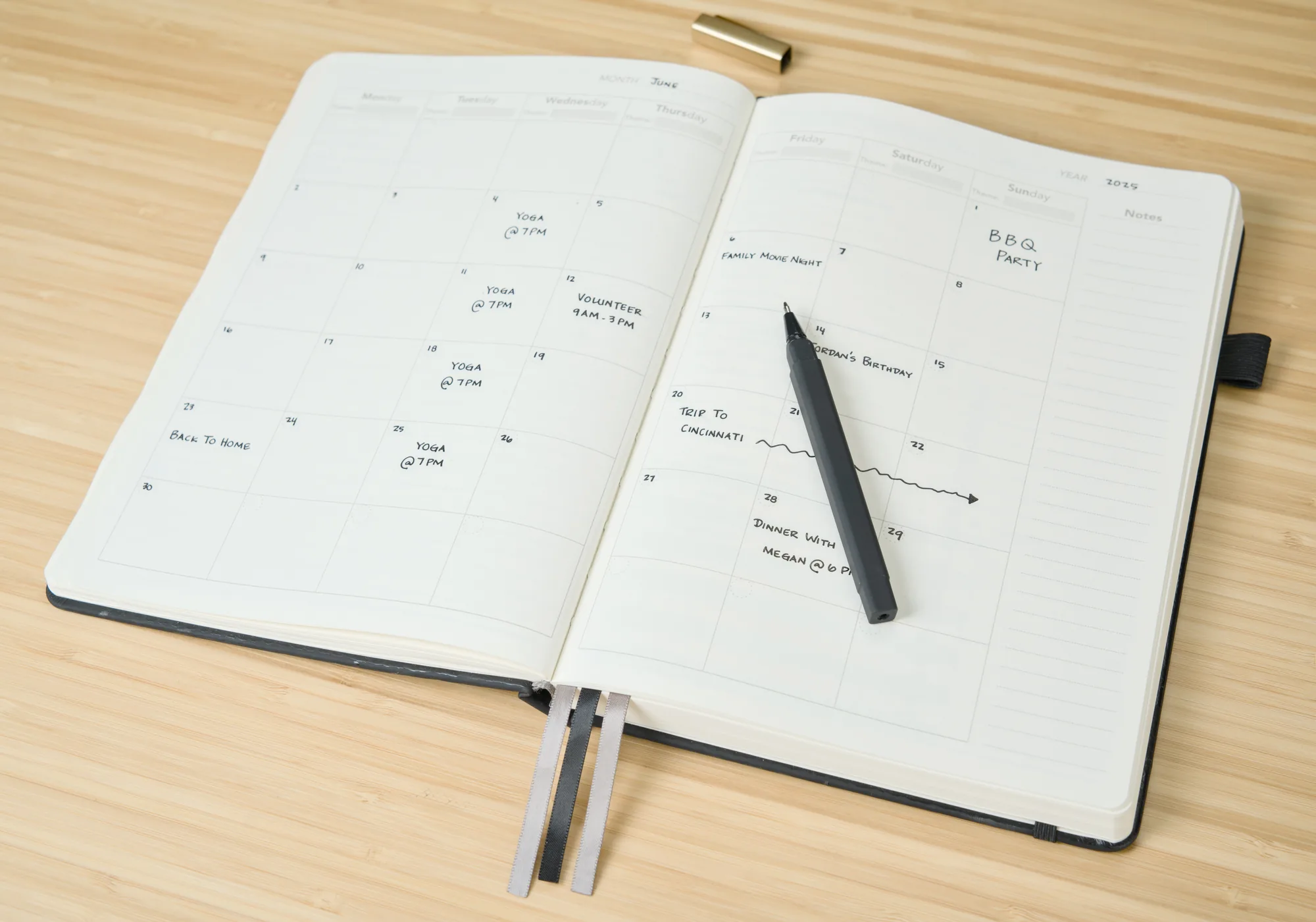 Open Novella Planner weekly layout with a pen on a wood desk